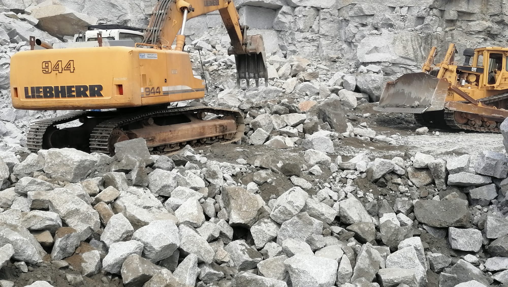 Excavator breaking rocks